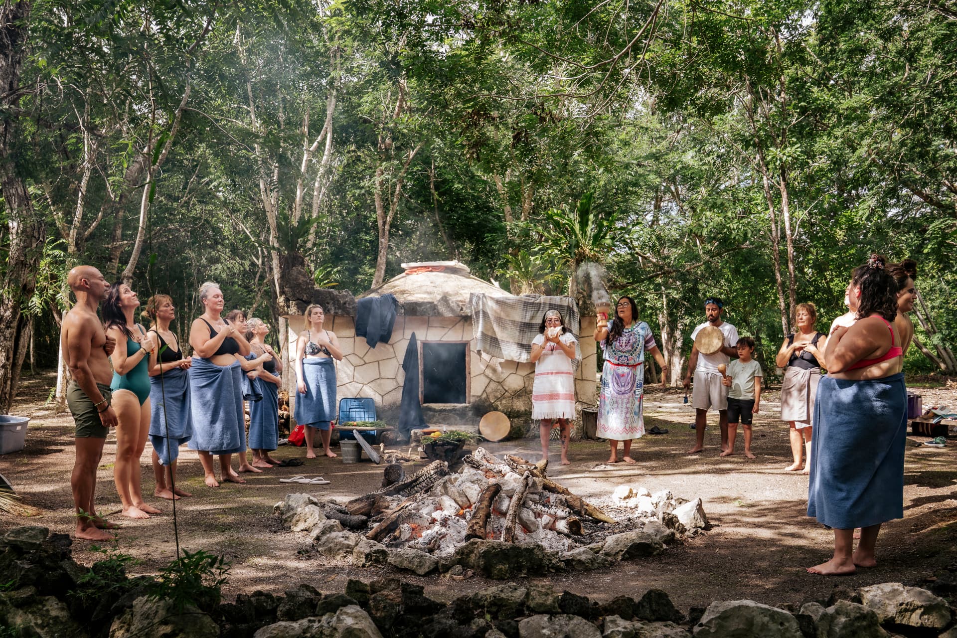 Cercle de participants autour du feu devant un temazcal dans la jungle mexicaine