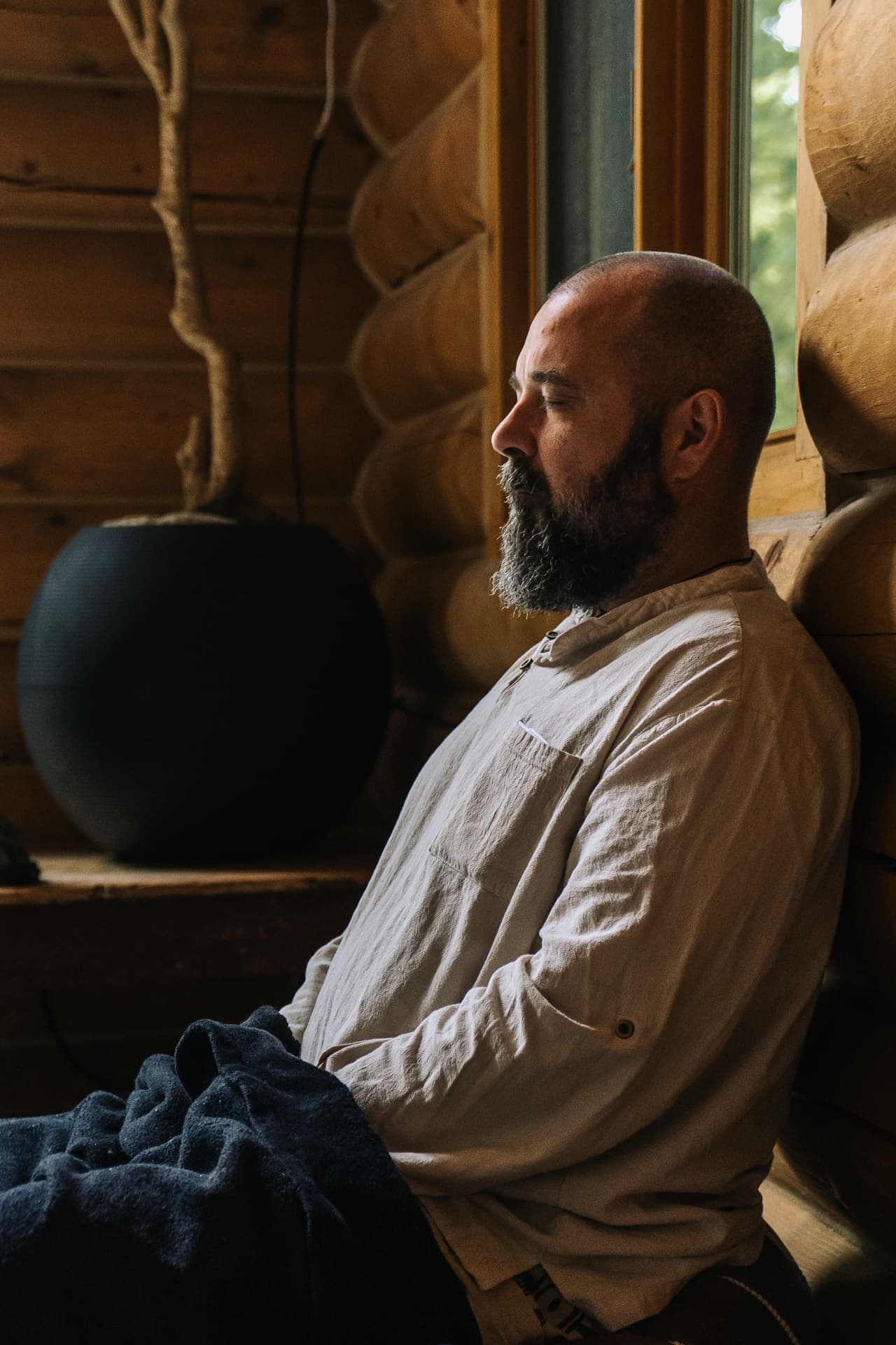 Participant en méditation près d'une fenêtre du chalet